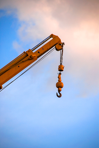 Group of work aerial platforms,  cherry pickers and scissor lifts models, against blue sky.