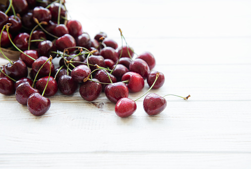 Fresh red cherries fruit on a white wooden background