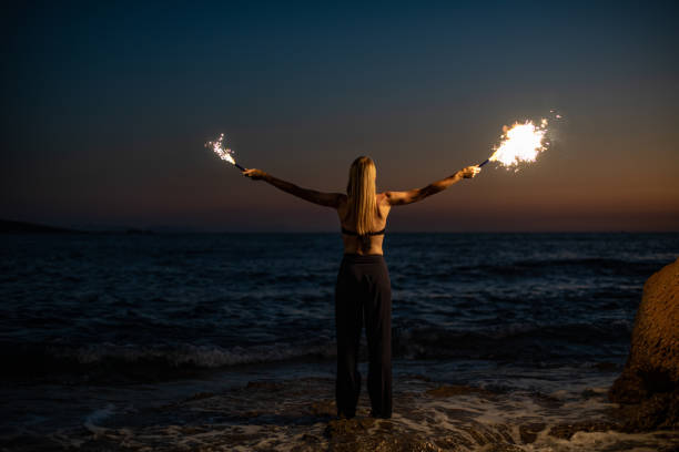 istock Young Woman Burning Sparkler at Sunset 1413392126