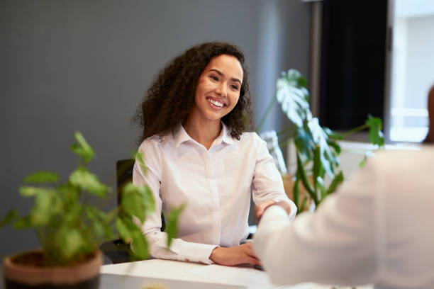istock Greeting with a handshake during promotion interview in a corporate, modern office. Female Human Resources professional giving a welcome or congratulation gesture to auccessful client or employee 1413392386