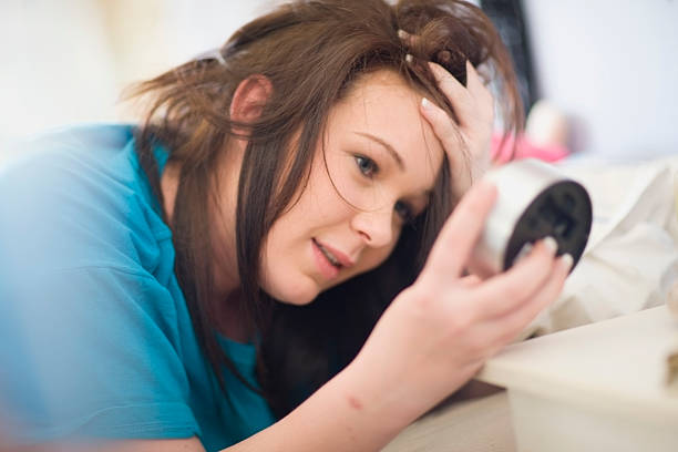 Teenage girl checking alarm clock  oversleeping stock pictures, royalty-free photos & images