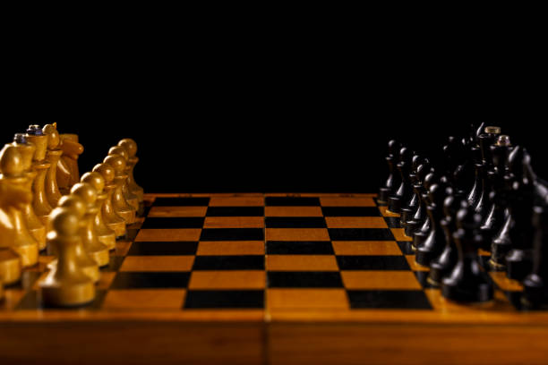 istock Chessboard with white and black pieces on a black background. Soft focus, copyspace 1413394521