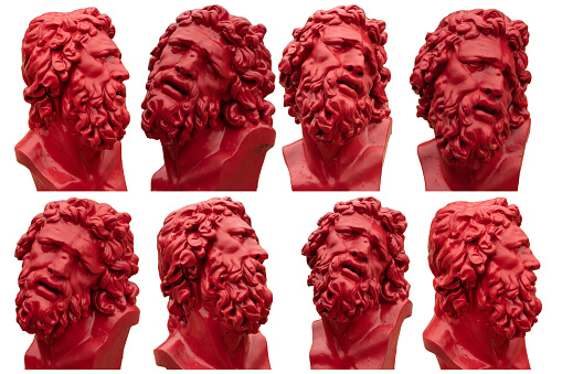 red gypsum copy of ancient statue heads isolated on a black background. Plaster sculpture mans faces.