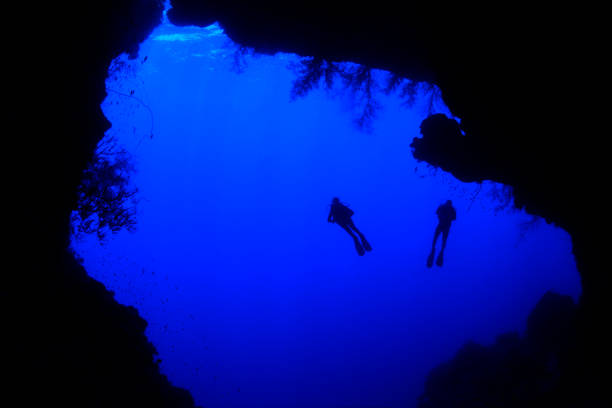 istock Silhouette of divers exploring underwater cave Red Sea, Egypt 1413398987