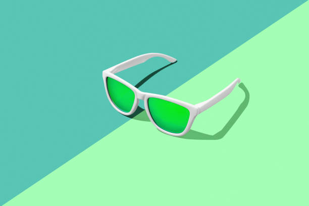 Green sunglasses on split green tones background with copy space.