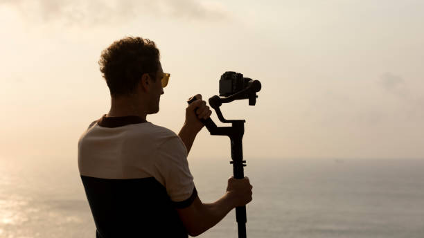 istock Digital nomad vlogger who shoots travel content with a stabilizer camera that stabilizes for the best landscape shots for blogs and social media. Panning by Travel Videographer with Gimbal Stabilizer 1413404176