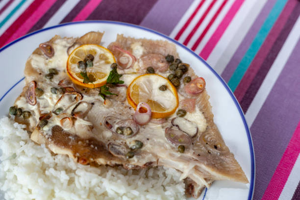 ray fish wings prepared with capers, shallot and lemons and served with rice, top view