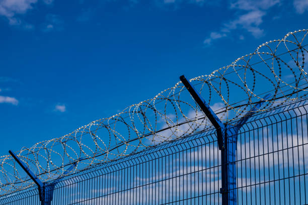 istock barbed wire fence against the blue sky 1413409403