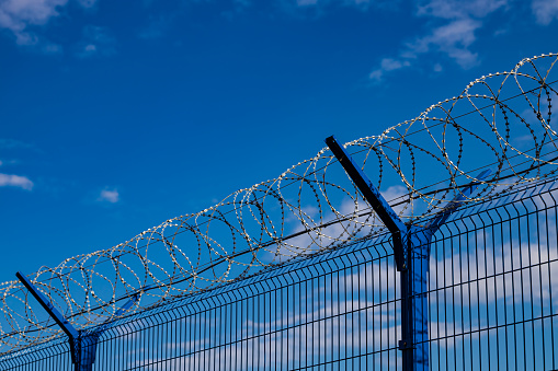 barbed wire fence against the blue sky. High quality photo