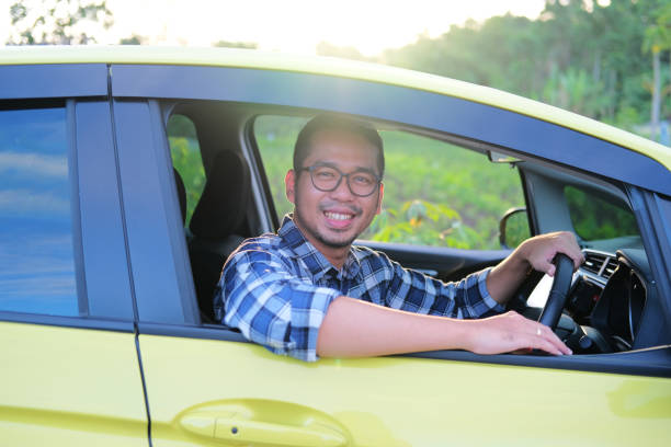 istock Asian man smiling confident from inside his car 1413414881