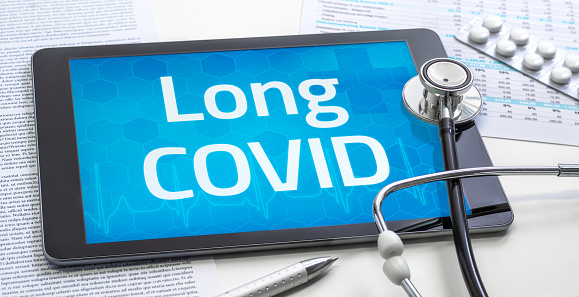 Una tableta con la palabra Long COVID en la pantalla photo