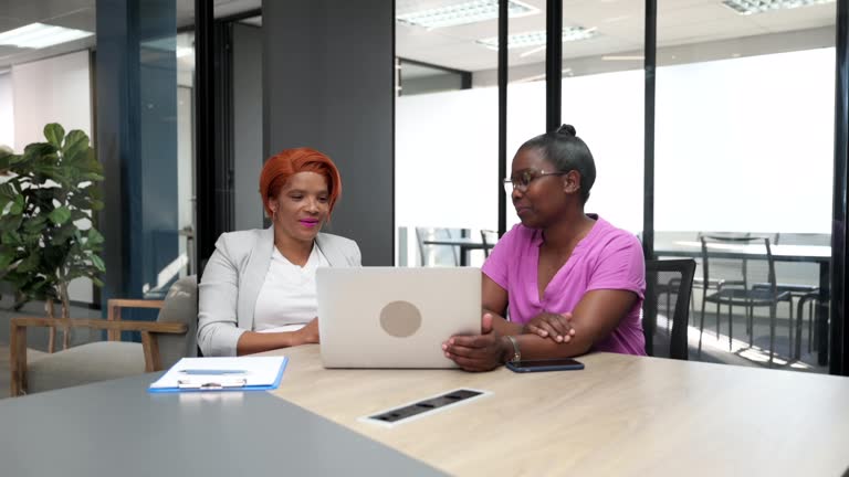 Wide shot two women meeting in boardroom