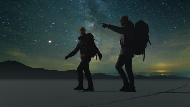 The two travelers walking on a starry sky background. slow motion