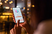 Woman checking and analysing stock market data with mobile app on smartphone