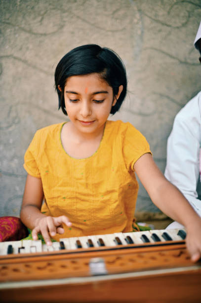 istock A cute little girl playing a Harmonium 1413429140
