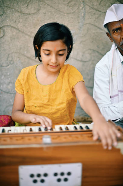 istock A cute little girl playing Harmonium. 1413429257