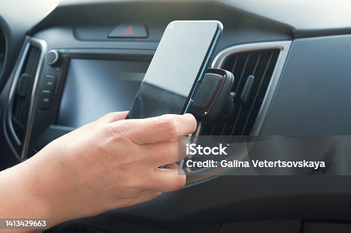 istock Driver attaches the smartphone to a magnetic holder 1413429663