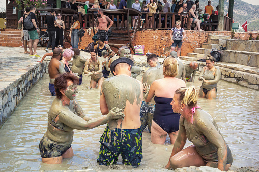 Dalyan, Turkey - May 9, 2022. People take mud baths in the pool of a natural spring on the shore of the lake