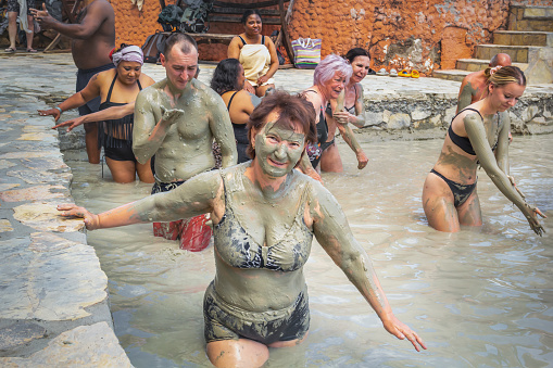 Dalyan, Turkey - May 9, 2022. People take mud baths in the pool of a natural spring on the shore of the lake