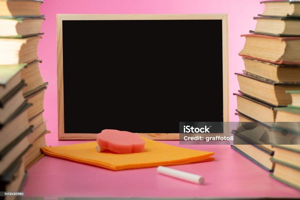 School books, white chalk and black board. School books, white chalk and black board. School board background. Back Stock Photo