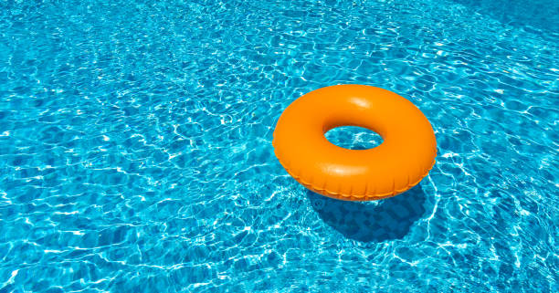 istock Orange ring floating in blue swimming pool. Inflatable ring, rest concept 1413435069