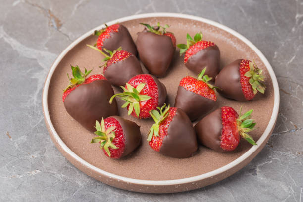 istock Top view on ceramic plate with dark chocolate covered strawberries. Dessert background.  Selective focus. 1413435609
