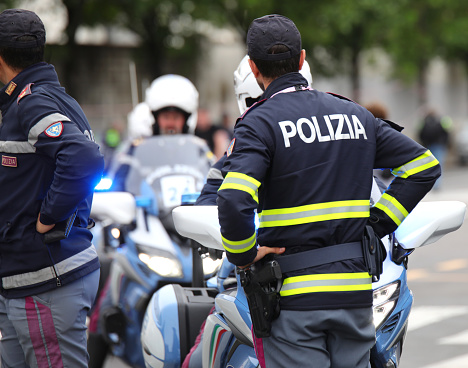 Verona, VR, Italy - May 29, 2022: Italian policeman in uniform with the text POLIZIA which means Police and the motorcycle of the road patrol