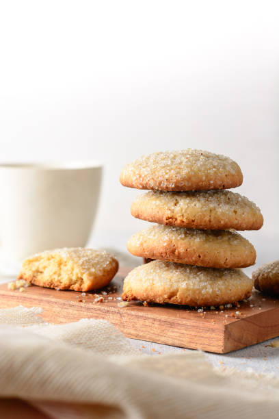 sugar cookies and a tea cup on the table sugar cookies, consist of butter, flour and sugar, close-up of baked sweet biscuits and tea cup in the background,soft-focus with copy space round sugar cookie stock pictures, royalty-free photos & images