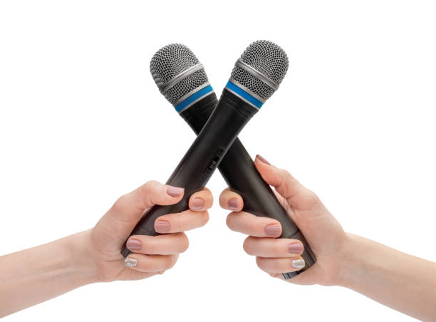 istock Woman's hands crossed audio microphones. Isolated on white. 1413437397