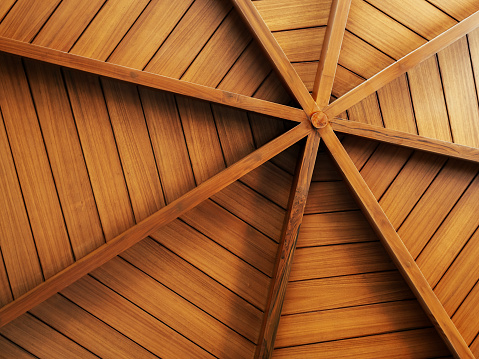 Wooden construction background, arranged to round shape, under the roof. Interior structure of a domed wood plank ceiling, circle pattern, spider web style.