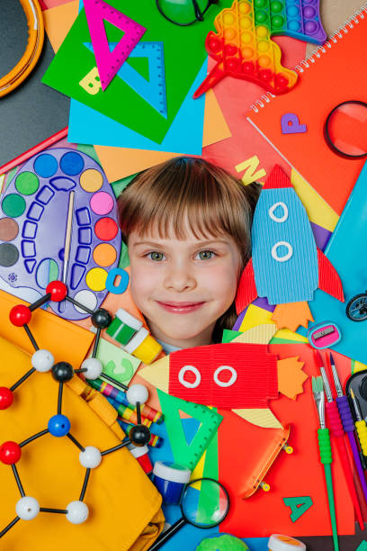 istock Funny girls face surrounded by different school stationery 1413439554