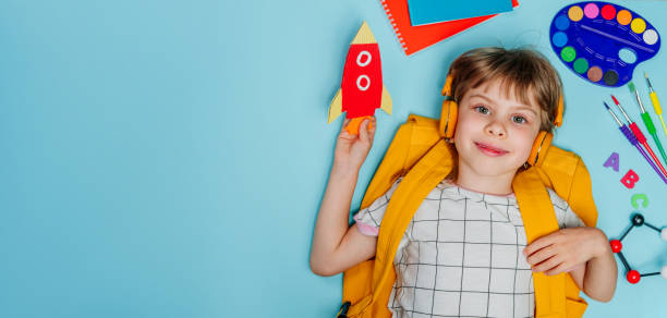 istock Cute girl surrounded by different school stationery 1413439573