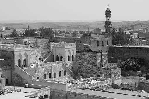 Black and white photo with the view of Midyat city with historical houses, mosque and Assyrian church