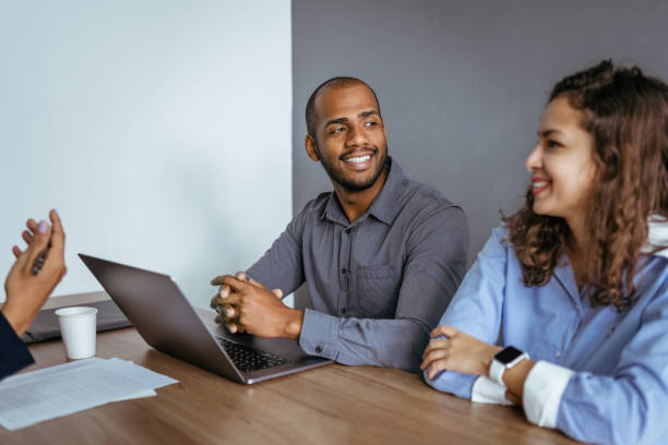 istock Smiling coworkers at meeting in office 1413442434