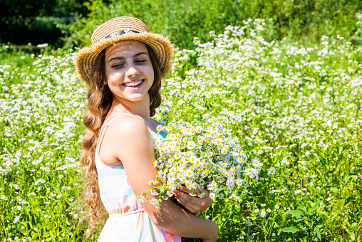 More beautiful blossom than ever. Happy girl smile on chamomile field. Little girl child natural landscape. Beauty look. Hair salon. Fashion style. Summer vacation.