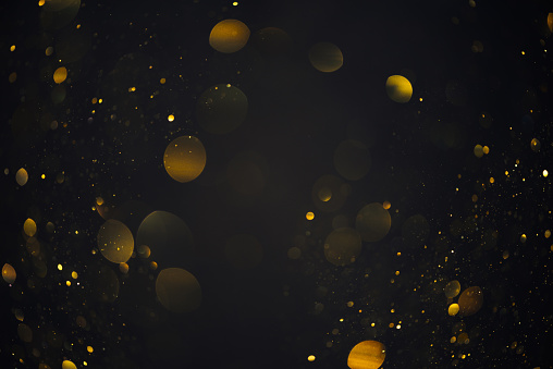 Gold glitter bokeh shiny dust particles lights abstract dark background