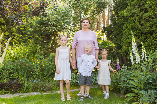 Family portrait. Woman smile. Two sisters and brother outdoors. Grandparent and children together. Summer vacation. Outdoor recreation. Leisure activity. Age. Grandmother and grandchildren