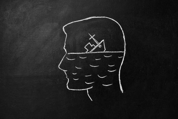 Broken hope concept. Silhouette of a human head drawn on a chalk board and a sinking ship of hope stock photo