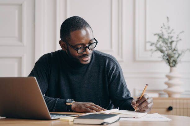 istock Confident young Afro american businessman working remotely online while sitting at home office 1413449563