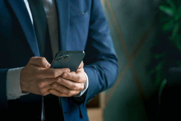 istock Businessman in suit with mobile phone in hands. Man typing message, using social net. Checking news. Making business meeting. Modern office.General manager,ceo.Calling to partner.Planning working day 1413450978