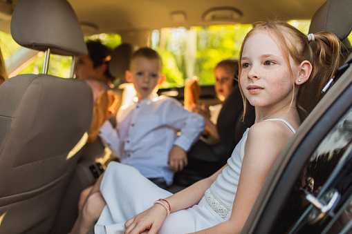 Redhead girl with braces on teeth freckles on face in car. Family car trip at summer. Go on trip. Journey. Outdoor recreation. Childhood. Leisure activity