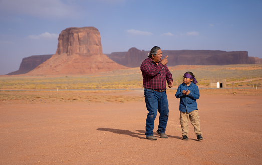 Navajo Father and son walking outdoors in Monument Valley