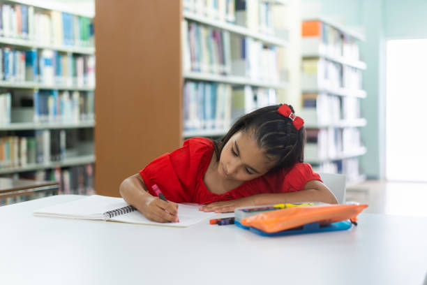 A little latin girl coloring on a notebook.