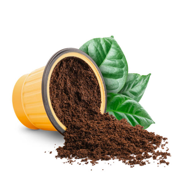istock Coffee scattered from capsule with green leaves isolated 1413453819