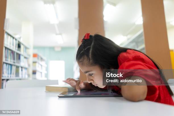 Shortsighted Little Girl Using Tablet With Face Close To Screen Stock Photo - Download Image Now