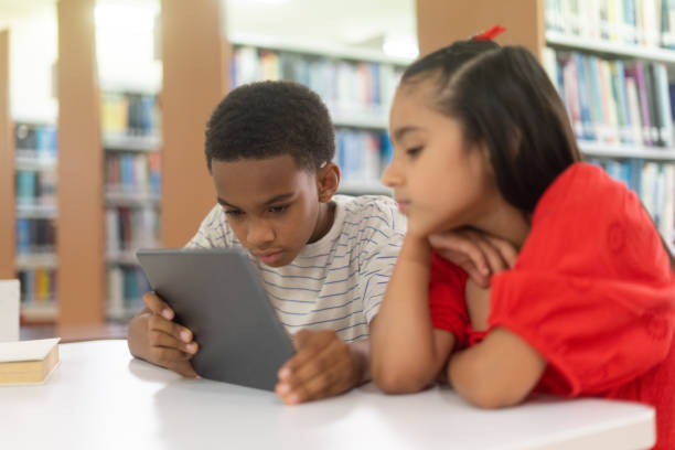 istock Kids with myopia looking at tablet close to face 1413455206