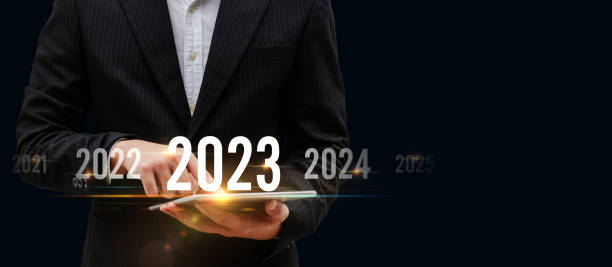 istock Business Trend. smart businessman investor using mobile tablet with virtual screen on dark background, change from 2022 to 2023, strategy, investment, business planning and happy new year concept 1413456644