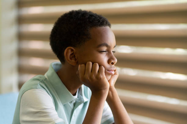 istock Little boy with eyes closed and head on hands 1413457731