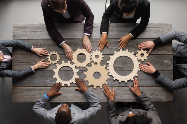 Business people joining gears