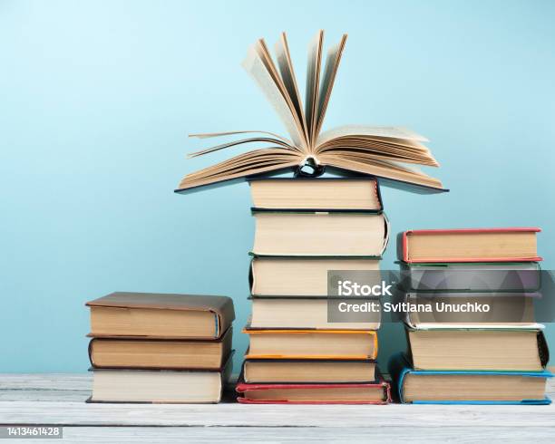 Open Stacking Book Hardback Colorful Books On Wooden Table And Blue Background Back To School Copy Space For Text Education Business Concept Stock Photo - Download Image Now